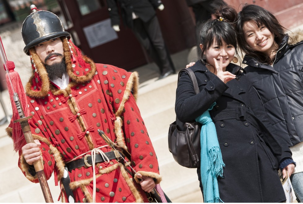 Chinese friends pose with a “guard” at a palace in Seoul.