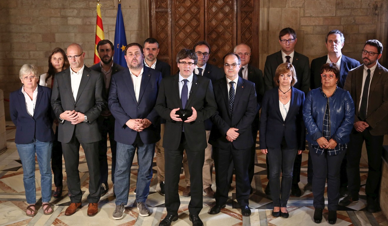 Catalan president Carles Puigdemont (centre) talking to the media next to members of his government on Sunday in Barcelona. Photo: AFP