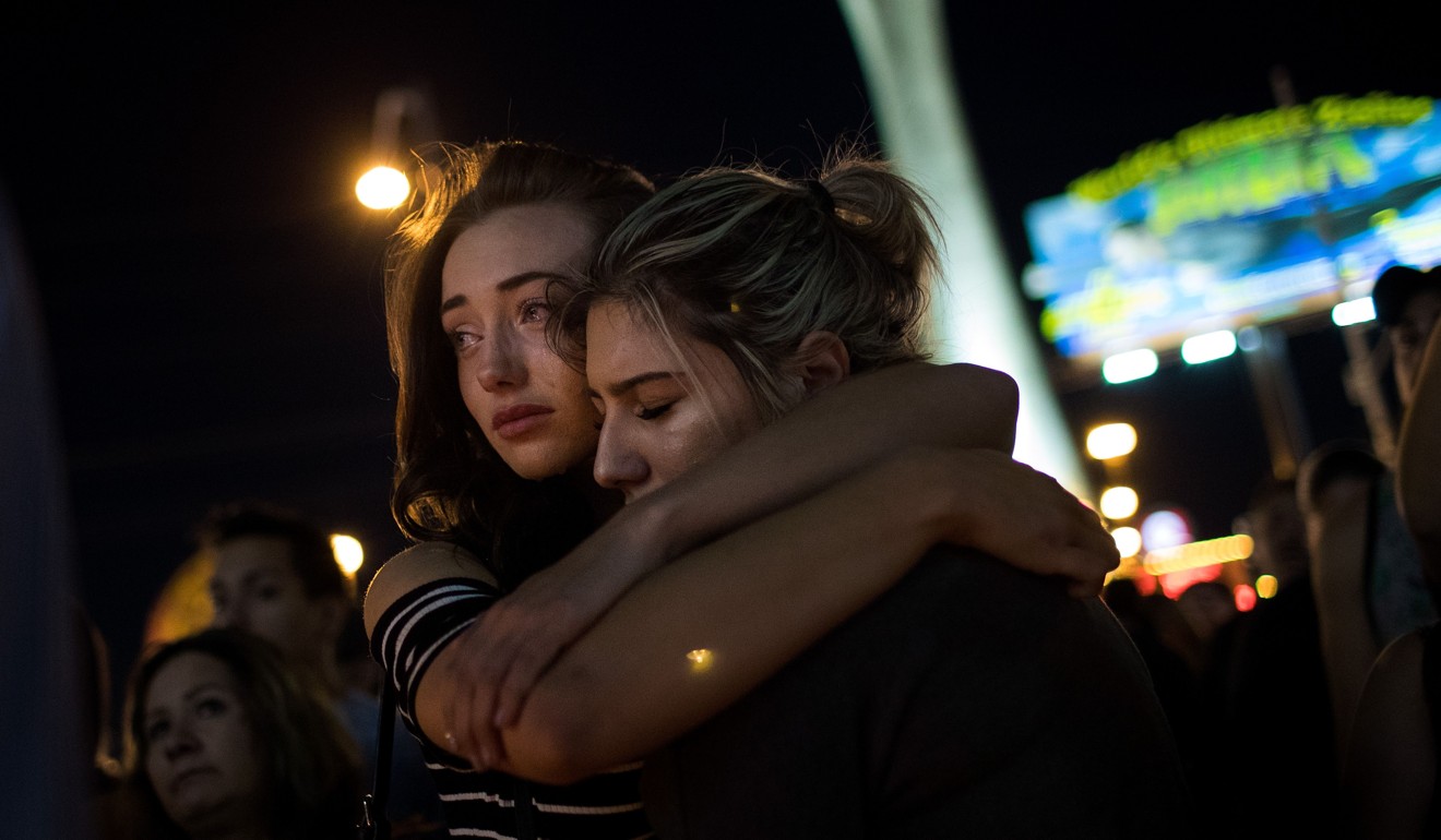 Mourners attend a candlelight vigil on Las Vegas Boulevard for the victims of Sunday night's mass shooting. Police and the FBI are investigating the motive and details surrounding gunman Steven Paddock. Photo: AFP