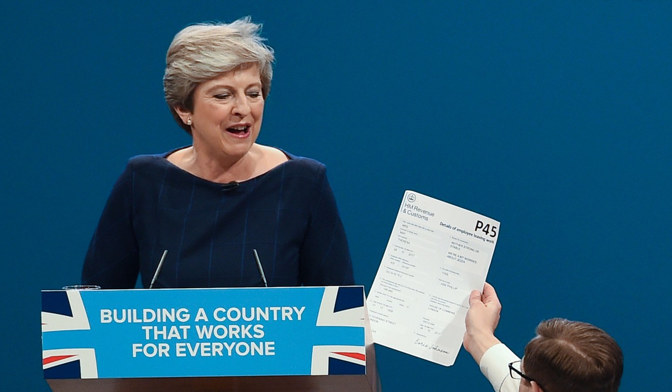 Protester and comedian Simon Brodkin gives a fake P45 (employee leaving form) to Britain's Prime Minister Theresa May during her speech at the Conservative Party annual conference in Manchester. Photo: AFP