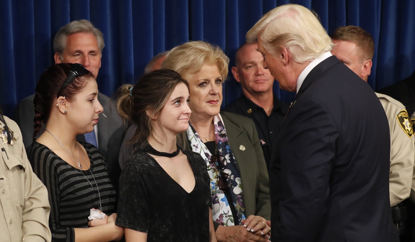 US. President Donald Trump is greeted by relatives of Las Vegas shooting victims, Shelby Stalker and Stephanie Melanson (left) . Photo: Reuters