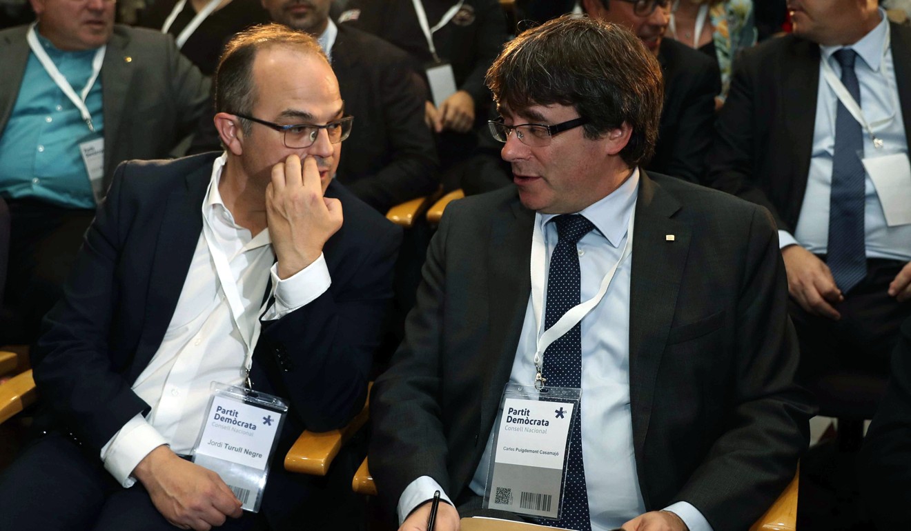 President of the Catalonian regional Government Carles Puigdemont (right) chats with his adviser Jordi Turull. Photo: EPA
