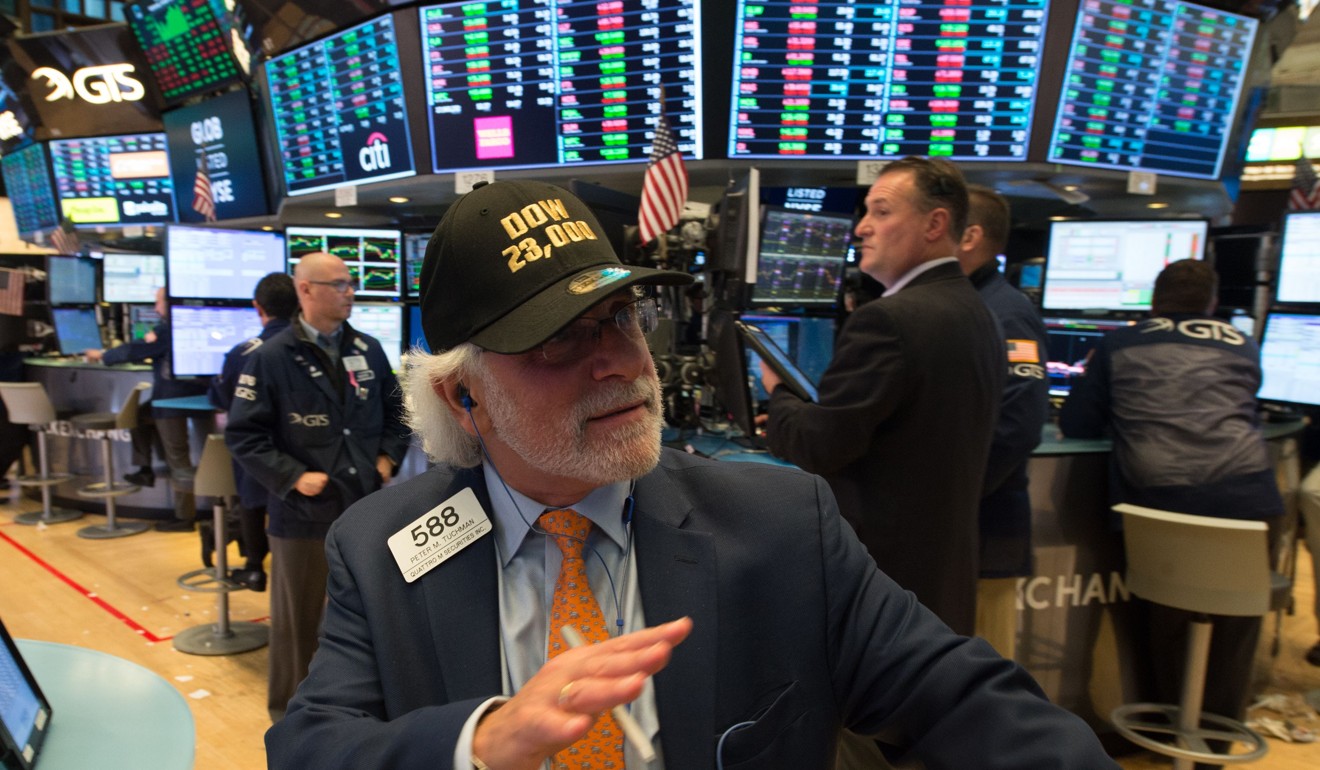 A trader wearing a DOW 23,0000 hat on the floor of the New York Stock Exchange. Markets are heading into uncertainty again as central banks wind back their loose monetary policies. Photo: AFP