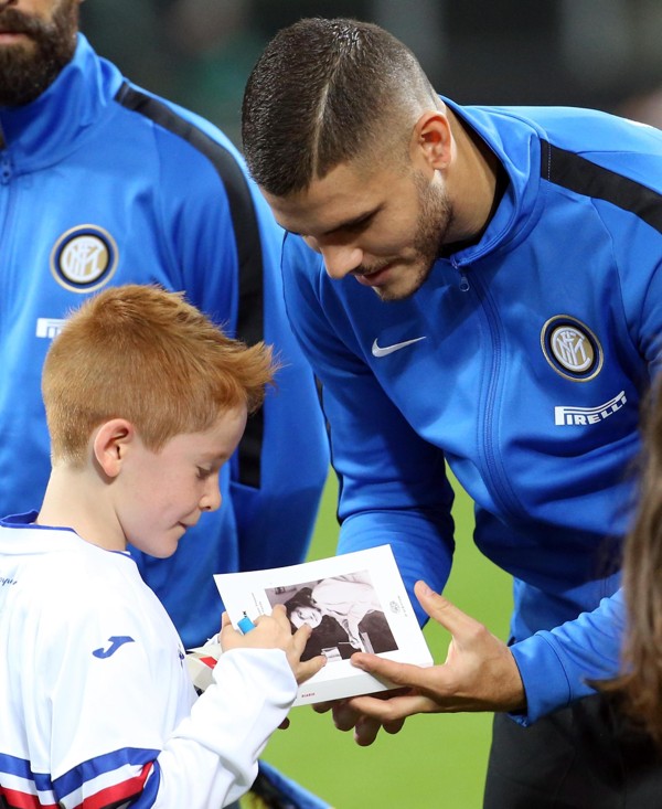 Inter captain Mauro Icardi hands Anne Frank’s diary to a child after signing it, prior the Serie A match against Sampdoria at the San Siro. Photo: AP