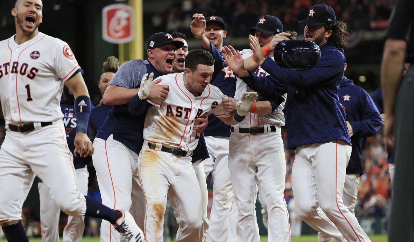 Houston Astros batter Alex Bregman (centre) is mobbed by teammates after driving in the game-winning run in the bottom of the 10th inning. Photo: EPA