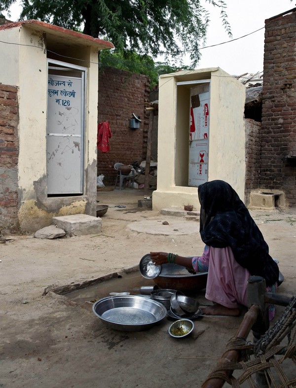 A villager washes utensils near new toilets in Hirmathala, Mewat district in the state of Haryana. Photo: AFP