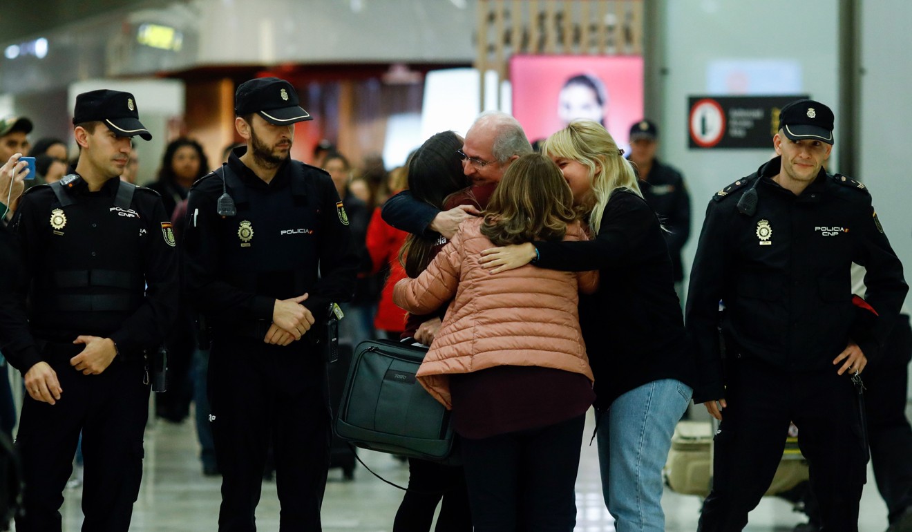 The mayor of Caracas, Antonio Ledezma hugs his wife and daughter as he arrives at Barajas airport, Spain. Photo: AFP