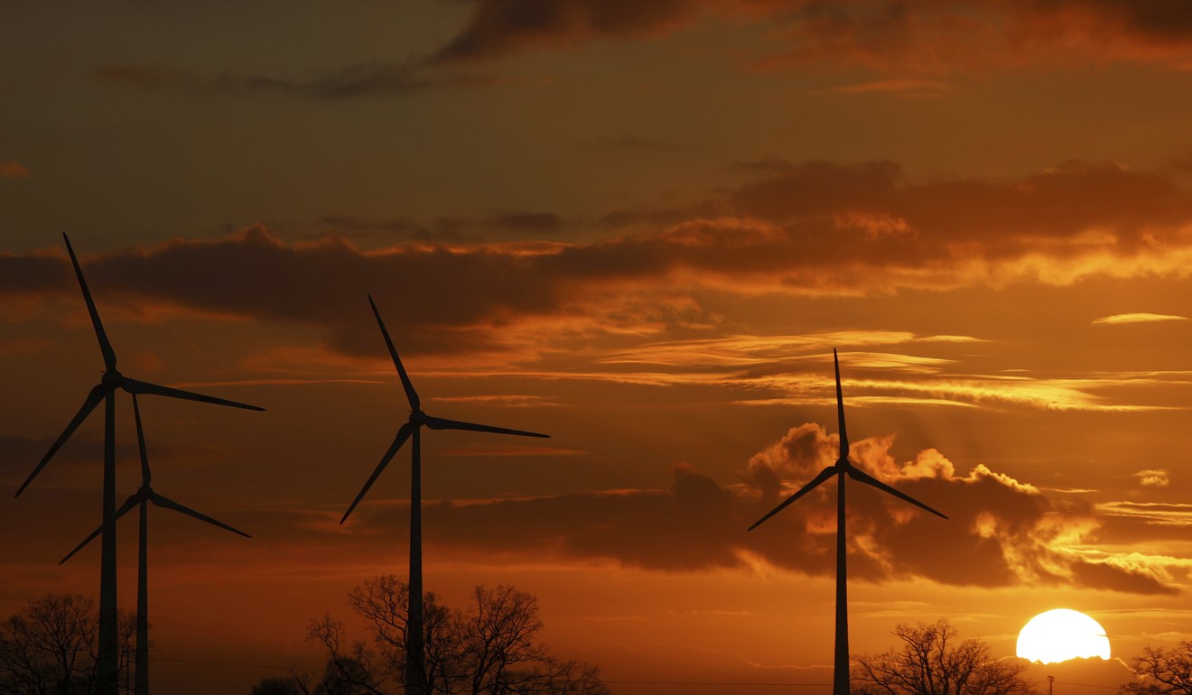 The sun sets behind wind turbines near Pokrent, Germany, as the world looks for alternative sources of energy aside from fossil fuels. Photo: DPA via AP