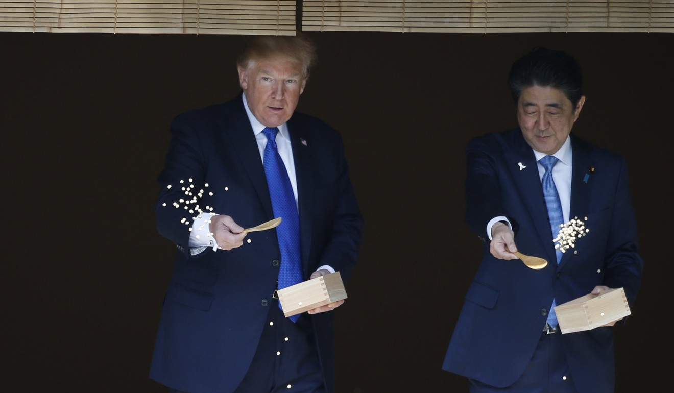 President Donald Trump and Japanese Prime Minister Shinzo Abe feed koi during a welcoming ceremony in Tokyo on November 6. Photo: AFP