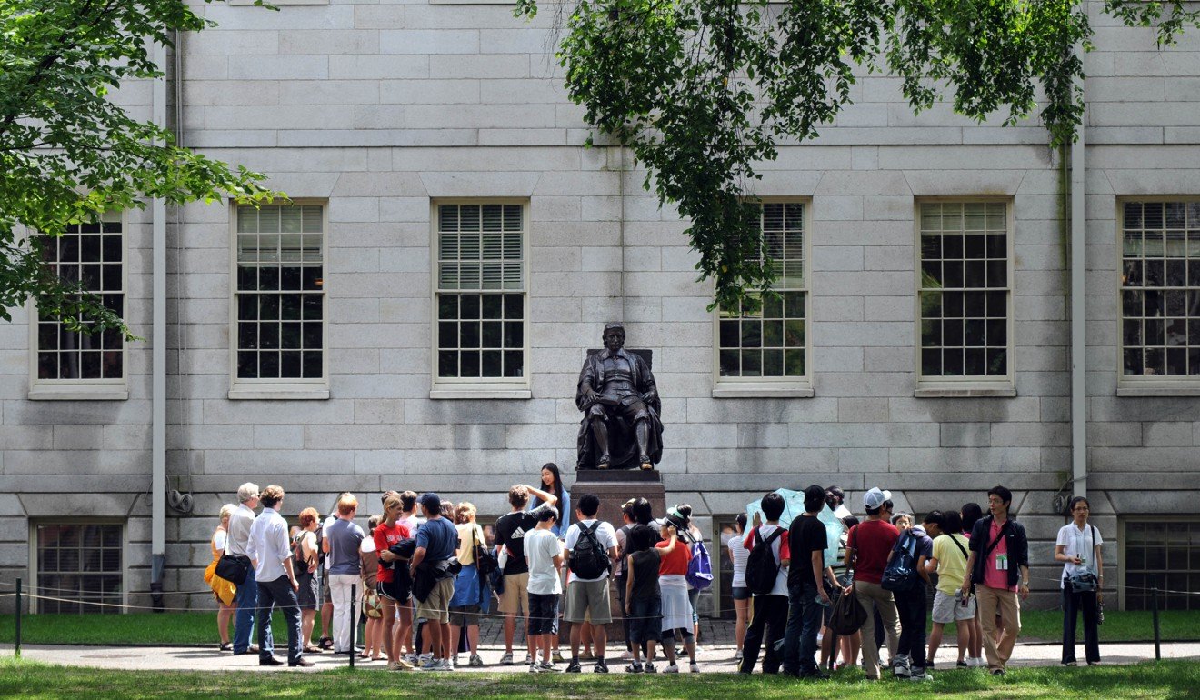 File photo of people visiting Harvard Yard and looking at the John Harvard statue. Photo: AFP
