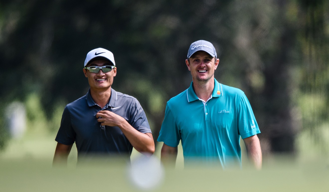 Li Haotong (left) walks with Justin Rose during the first round. Photo: AFP