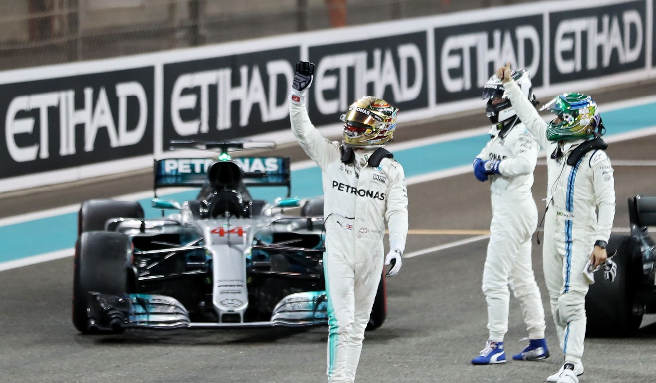 Mercedes' British driver Lewis Hamilton (centre) and Mercedes' Finnish driver Valtteri Bottas (second from right) wave to fans at the end of the Abu Dhabi Grand Prix, the last race of the season. Photo: AFP