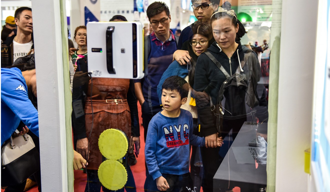 People watch a demonstration of how a window cleaning robot works at the China Hi-tech Fair in Shenzhen, on November 19. China should elevate more cities to provincial status. Shenzhen could immediately qualify. Photo: Xinhua