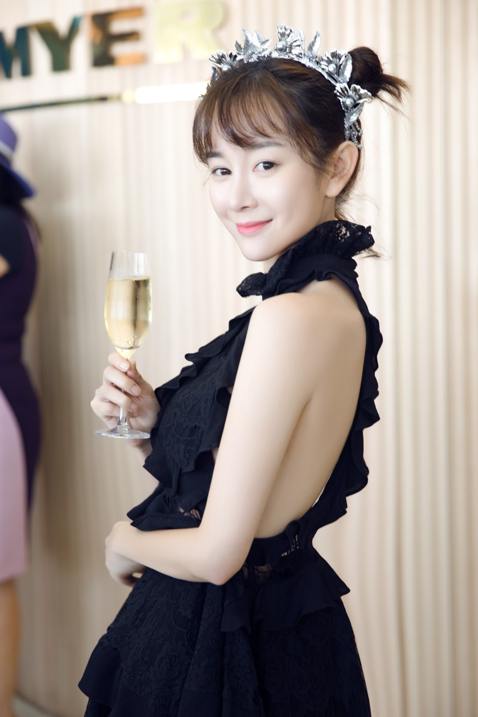 Zhang poses in an Elliatt dress with champagne in hand during the Spring Racing Carnival in Melbourne.