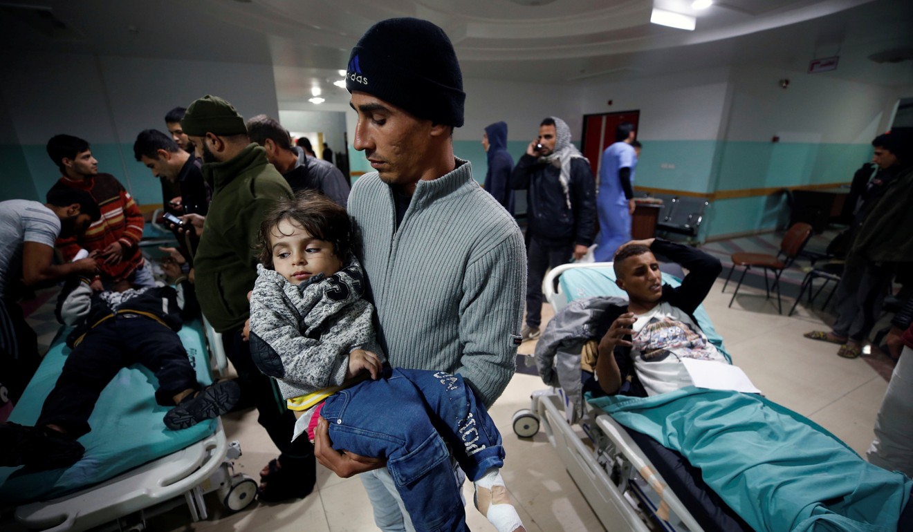 A Palestinian man carries his wounded daughter following Israeli air strikes on nearby militant targets in the Gaza Strip. Photo: Reuters
