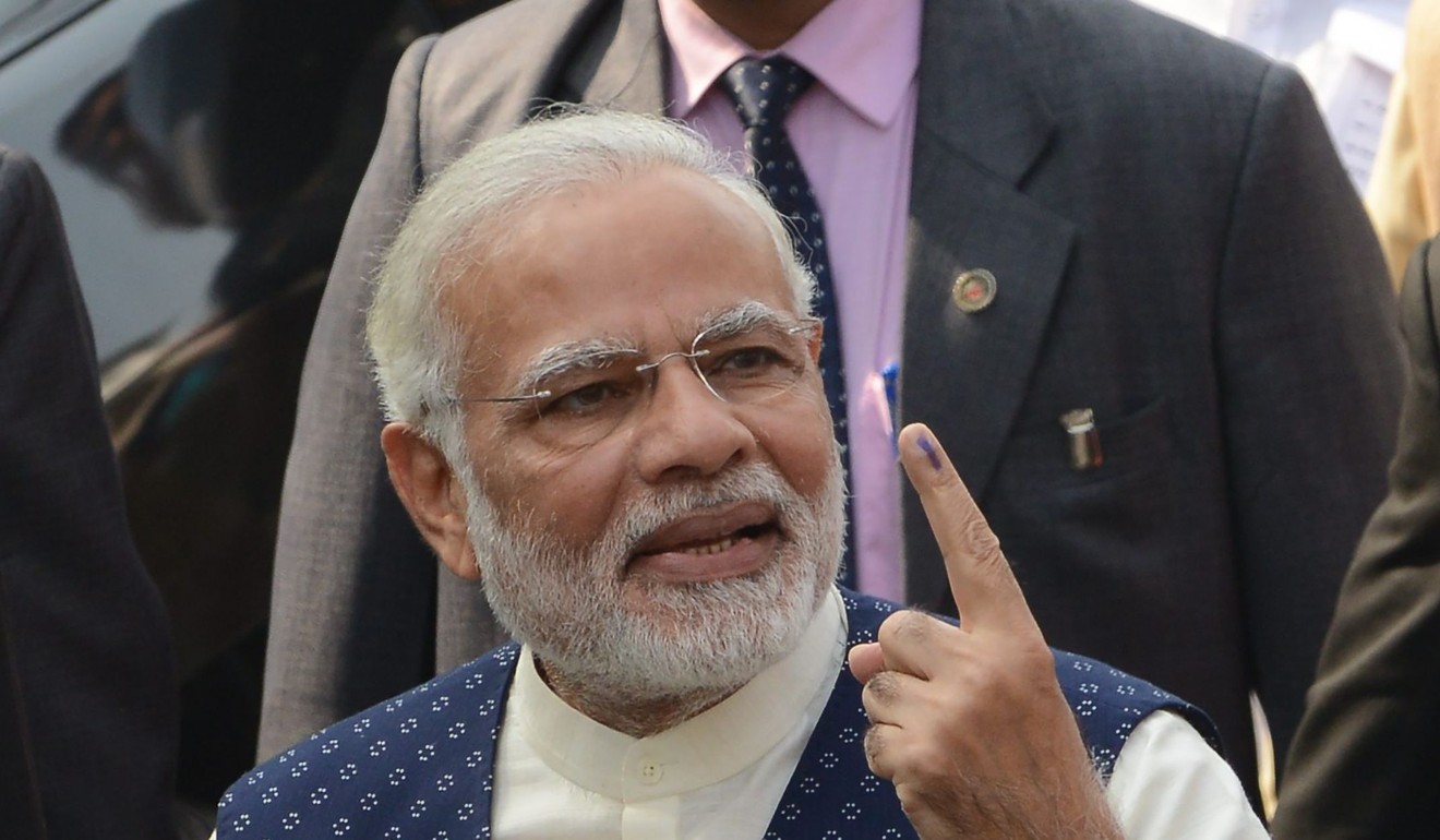 Indian Prime Minister Narendra Modi holds up his inked finger after casting his vote in Ahmadabad on December 14. Photo: AFP