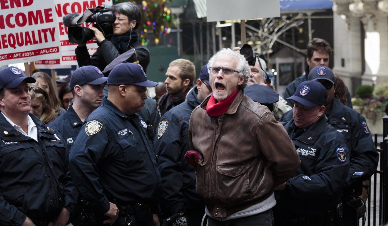 A man is arrested for blocking the entrance of the New York Stock Exchange during a protest against new tax legislation passed by the Republican-controlled House. Photo: EPA-EFE