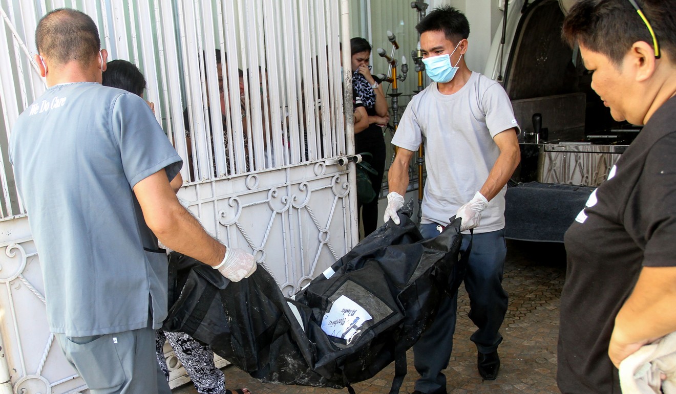 Funeral workers carry the remains of one of the victims. Photo: AFP