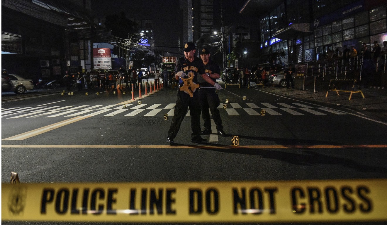Police on a street in Mandaluyong, following the shootings. Photo: EPA