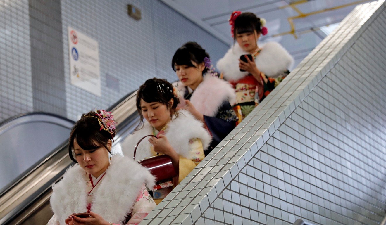 Japanese women wearing kimonos ride an escalator at a subway station after their Coming of Age Day celebration. Photo: Reuters