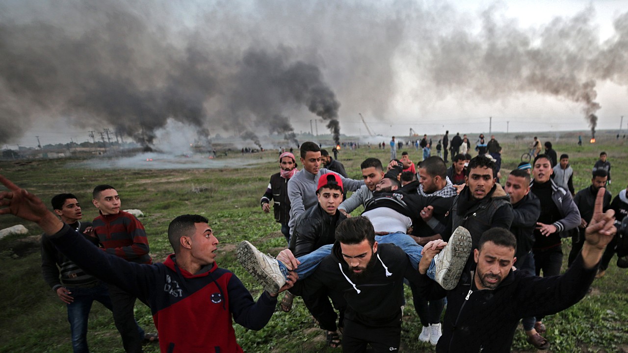 Palestinian protesters carry a wounded young man during clashes between Israeli troops and Palestinians near the border in eastern Gaza City, on January 12, 2018. More than 40 Palestinians protesters were injured during the clashes east of Gaza Strip. Photo: EPA-EFE