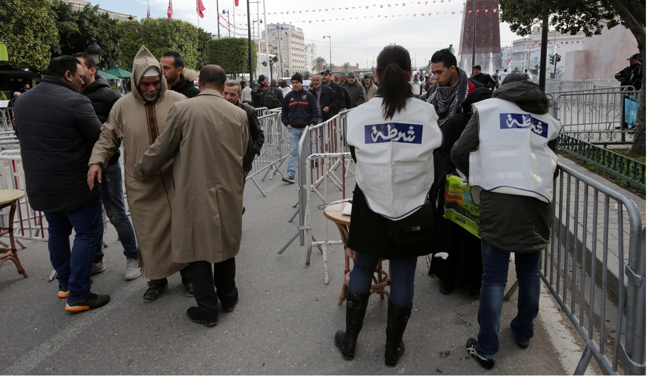 Police check demonstrators as they arrive at a demonstration on the seventh anniversary of the toppling of president Zine El-Abidine Ben Ali, in Tunis. Photo: Reuters