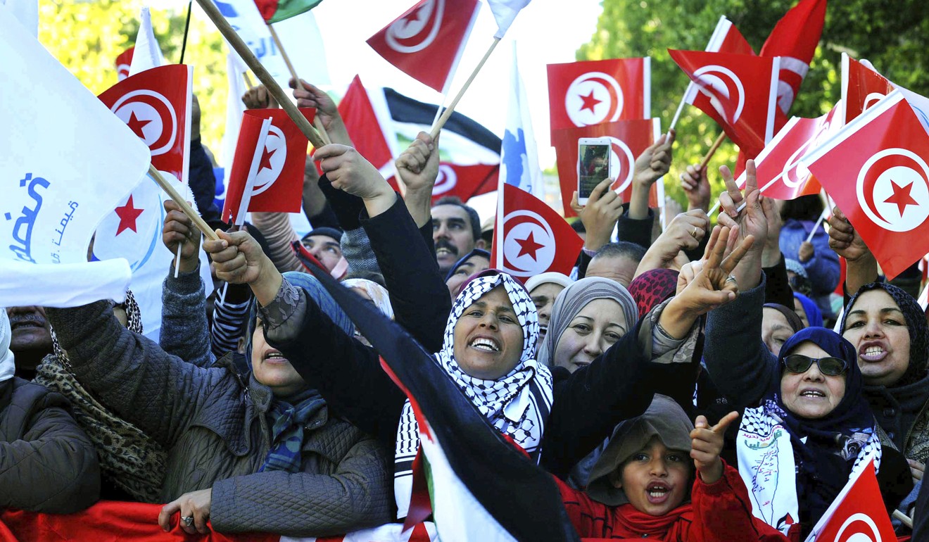 People gather in streets to mark the 7th anniversary of the popular uprisings in Tunis on Sunday. Photo: AP