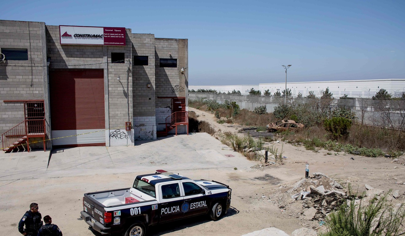 State Police officers stand guard by the warehouse where the entrance of a tunnel used to smuggle people was found at the US-Mexico border on August 27, 2017 in Tijuana. Photo: AFP