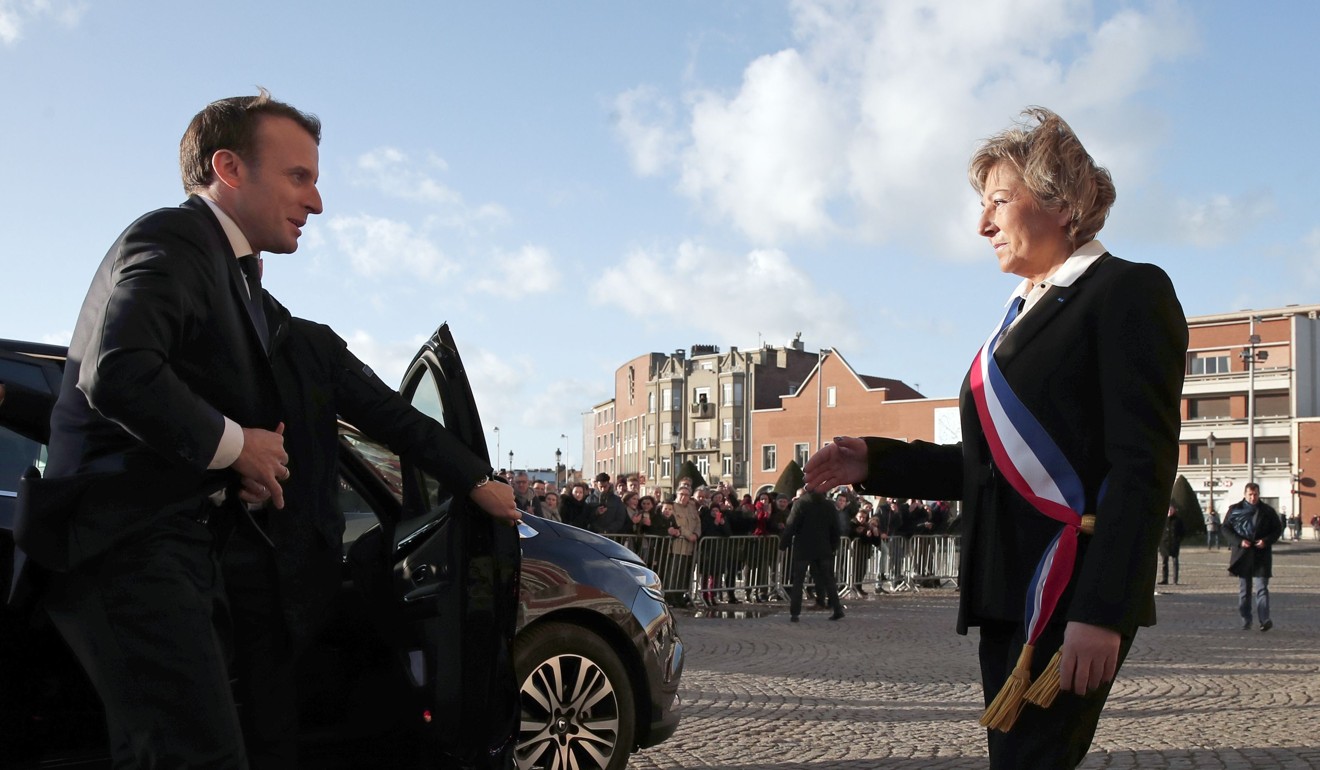 French President Emmanuel Macron (left) is welcomed by mayor of Calais Natacha Bouchart in front of the Calais' townhall, northern France, on Tuesday. Photo: AFP