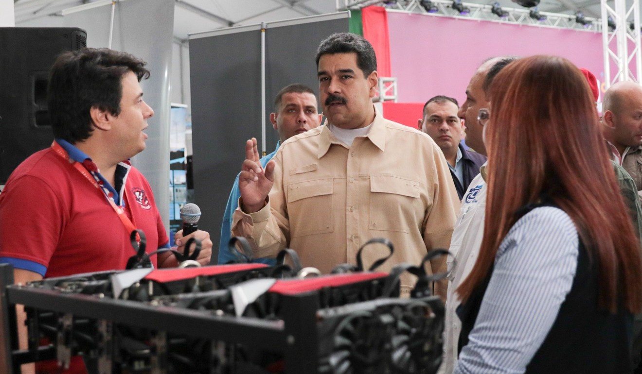 Venezuelan President Nicolas Maduro (C) speaks in front of a computer used to mine cryptocurrency Ethereum at the International Science and Technology Fair (FITEC) in Caracas on December 3, 2017. Photo: AFP