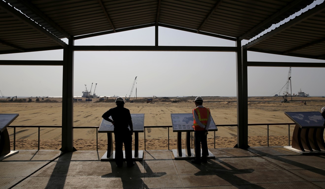 Visitors read promotional material displayed on the construction site for the Colombo Port City in Colombo, Sri Lanka, on January 2. The US$1.4 billion port city, to be built on land reclaimed from the Indian Ocean, was initiated as part of the Belt and Road Initiative. Photo: AP
