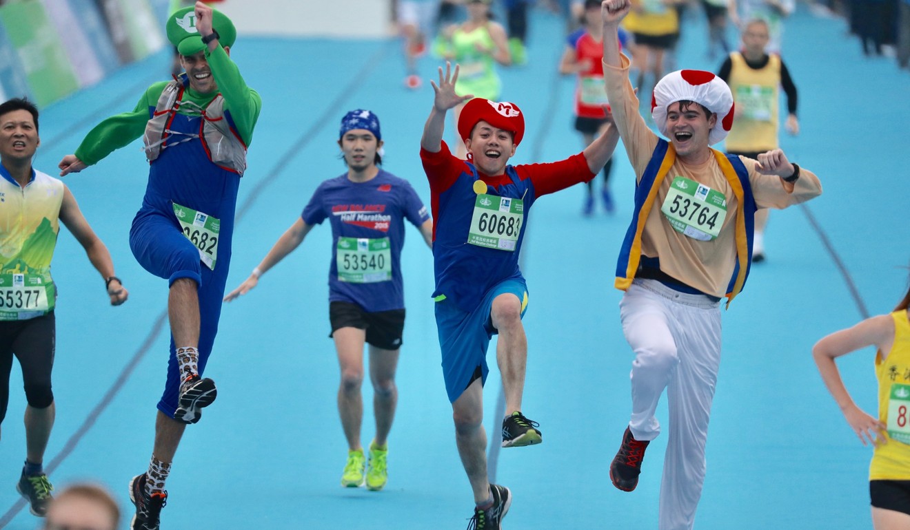 Runners dressed in Super Mario costumes cross the finish line at the Hong Kong Marathon. Photo: Nora Tam