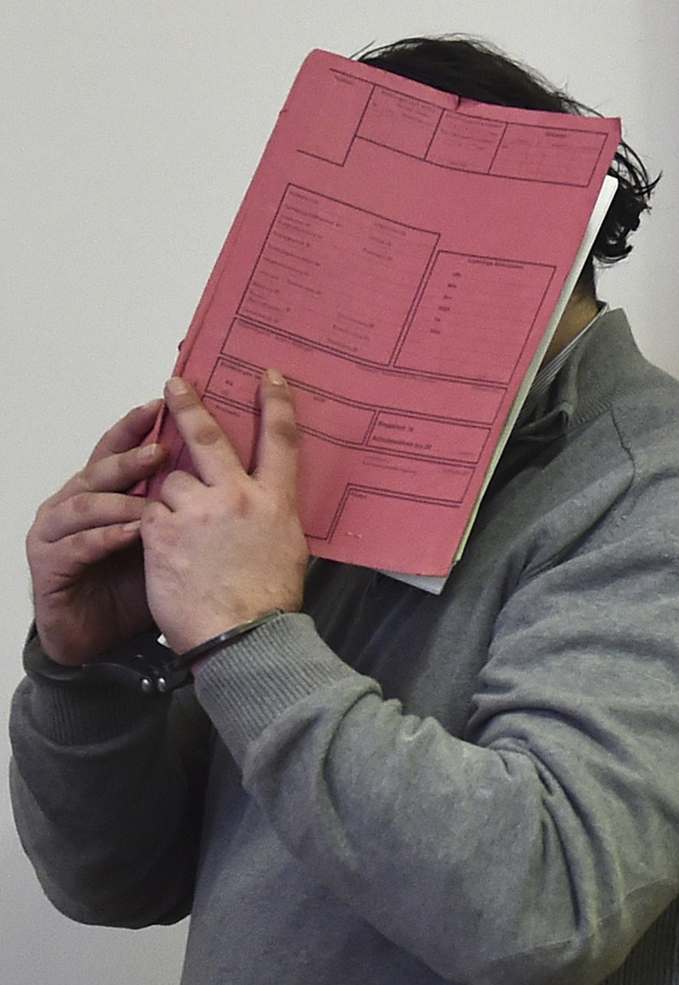 In this February 26, 2015 file photo, former nurse Niels Hoegel covers his face with a file at the district court in Oldenburg, Germany. Prosecutors in Oldenburg said on January 22, 2018 that they have charged Niels Hoegel with 97 more counts of murder. Photo: DPA via AP