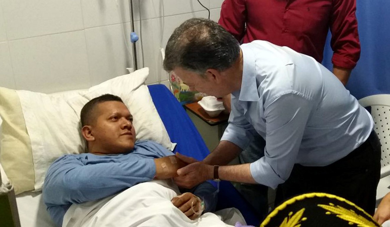 Colombian President Juan Manuel Santos visits one of the wounded policemen in hospital. Photo: EPA