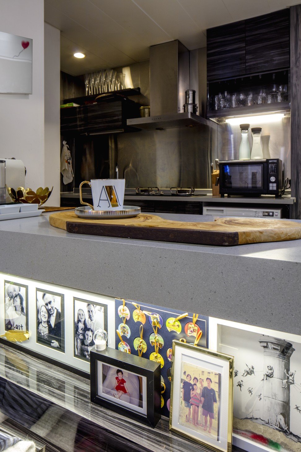 Pictures and prints, including by graffiti artist Banksy, adorn the shelving in the kitchen.