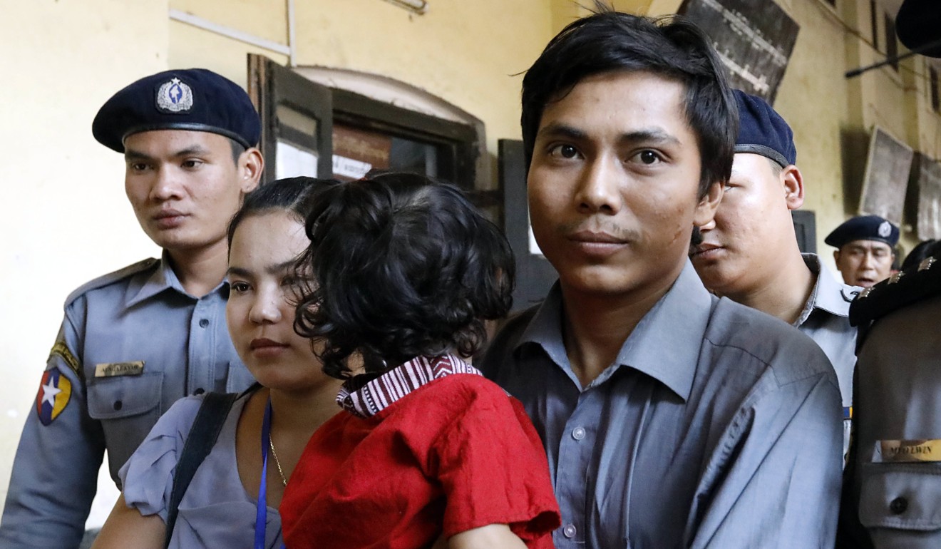 Reuters journalist Kyaw Soe Oo holds his daughter as he walks with his wife to the court in Yangon for his bail hearing. Photo: EPA