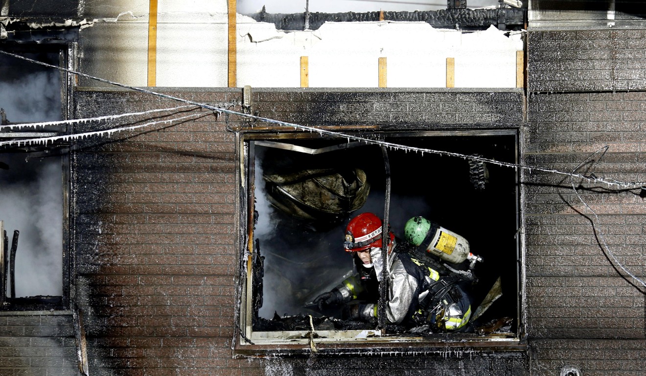 A firefighter inspects the damage after a fire gutted a support facility for elderly people on welfare. Photo: Reuters