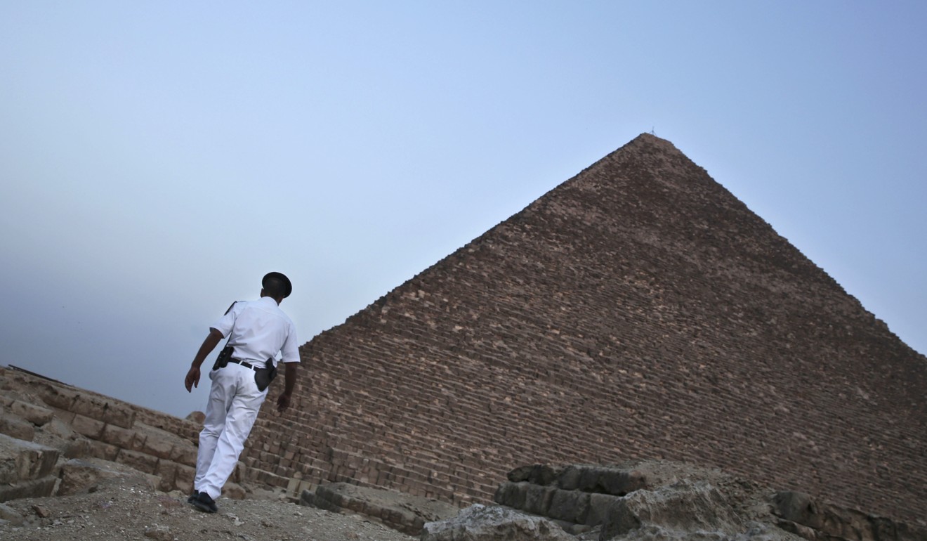 An Egyptian policeman walks near one of the pyramids in Giza, Egypt. Photo: AP
