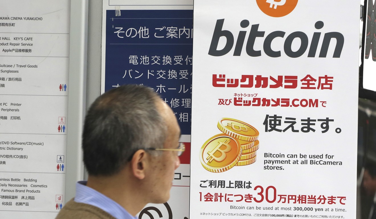 In this January 19, 2018, photo, a man walks past a poster of bitcoin displayed at a retail store in Tokyo. Photo: AP
