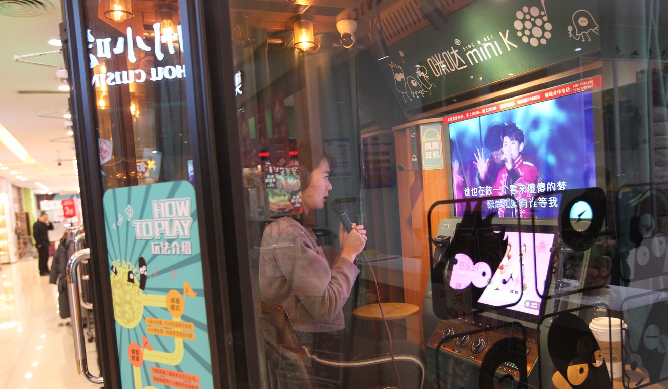 Jodie Zhou sings a song at a mini Karaoke box in a shopping centre in Beijing. Photo: Simon Song