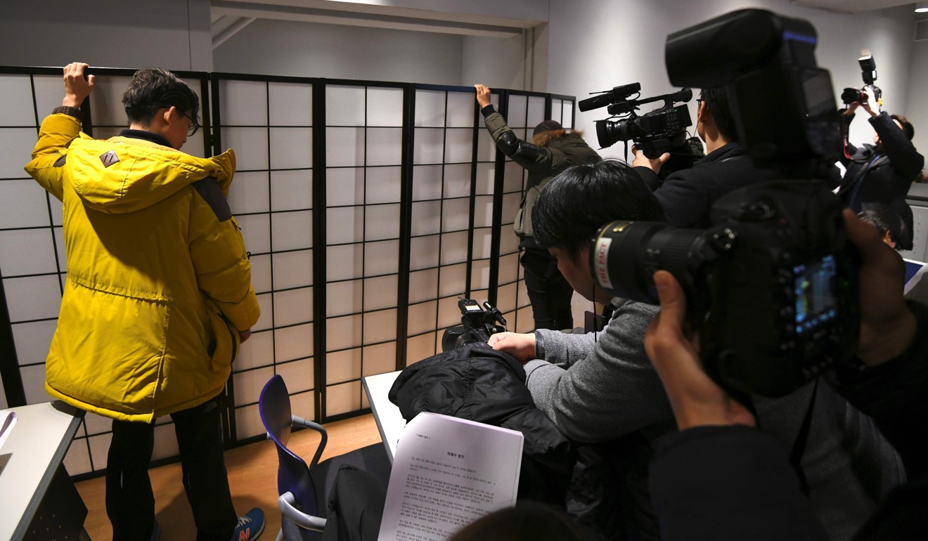 File photo from December 2017 of staff holding a white screen in Seoul while an anonymous South Korean actress speaks from behind it during a press conference in which she accused Kim Ki-duk of abusing her. Photo: AFP