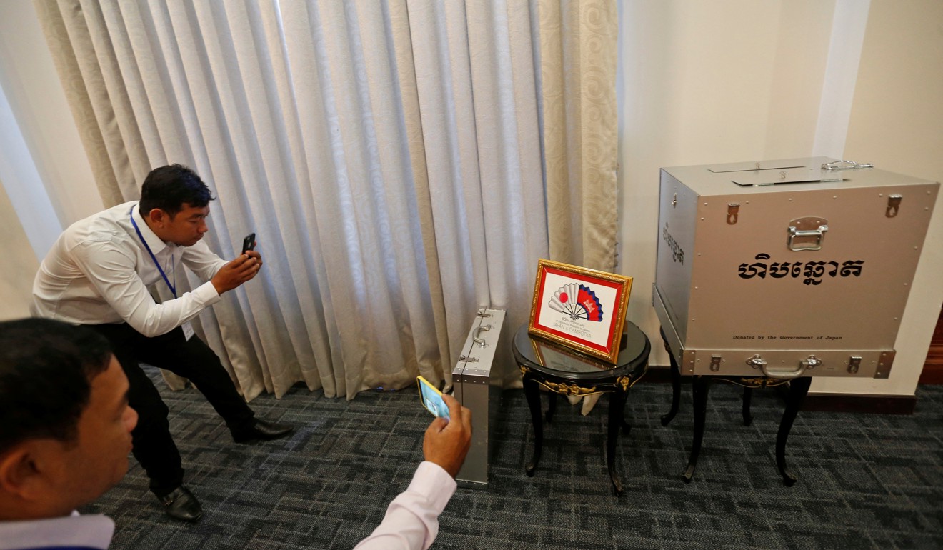 Journalists take photos of a ballot box donated by Japan. Photo: Reuters