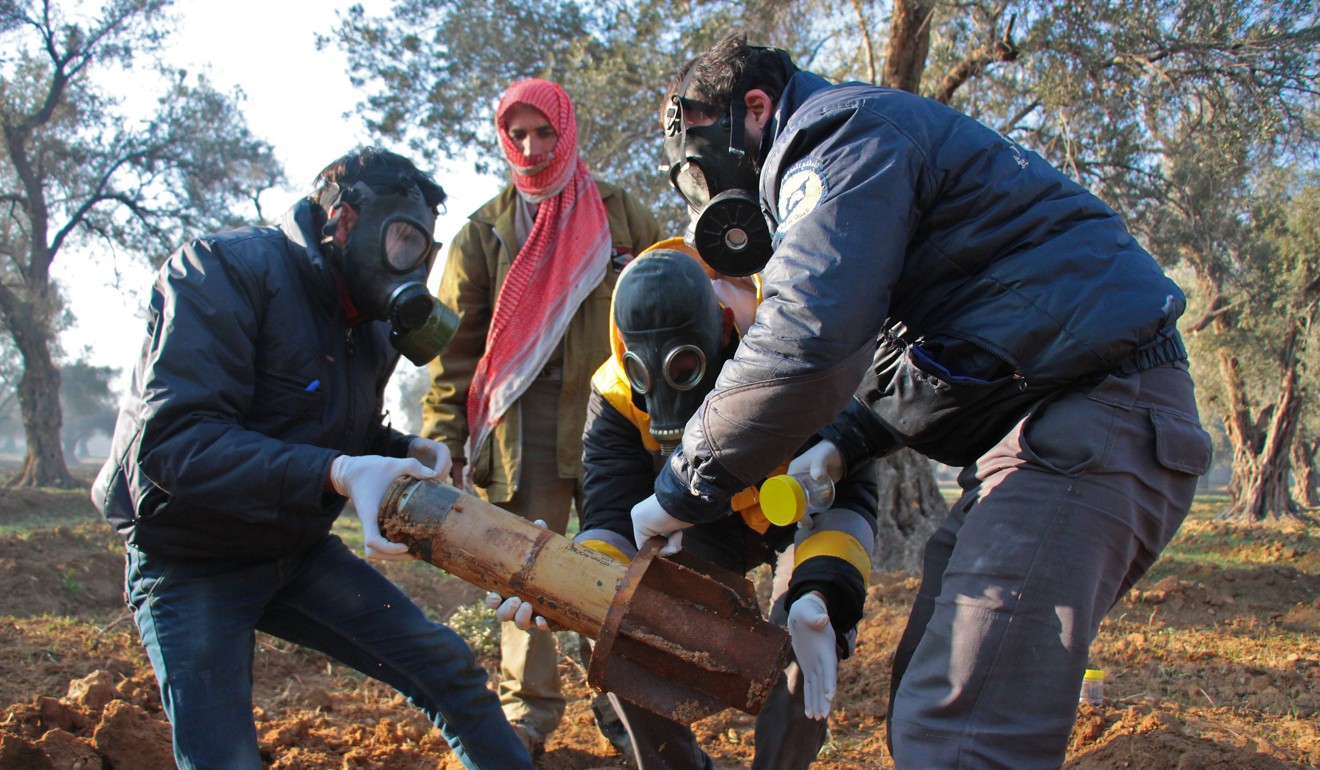 A picture taken on February 1 shows members of a rebel civil defence unit removing the remnants of a rocket reportedly fired by Syrian government forces on the outskirts of the rebel-held besieged Syrian town of Douma in the eastern Ghouta region. Photo: AFP