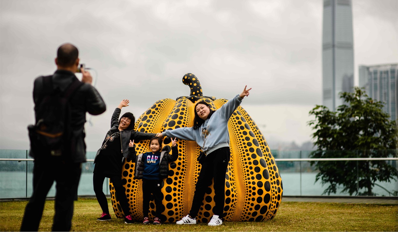 A family takes photos in front of Japanese artist Yayoi Kusama's Pumpkin: big, 2008 at the Harbour Arts Sculpture Park in Hong Kong. Photo: AFP