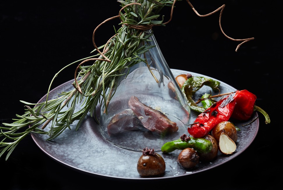 A dish of charcoal grilled pigeon with rosemary smoke and sesame oil at Ta Vie