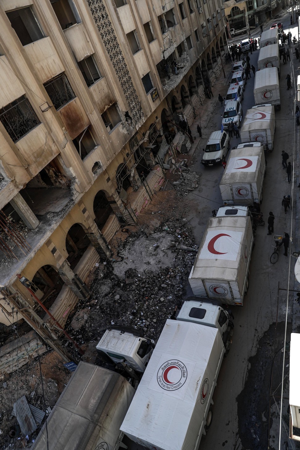 Aid trucks drive through a destroyed neighbourhood in rebel-held Douma. Photo: EPA