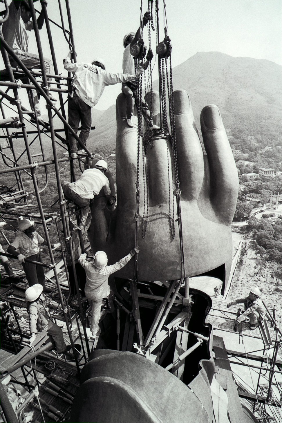 Construction workers manoeuvre one of the Big Buddha’s huge hands into place. Photo: SCMP