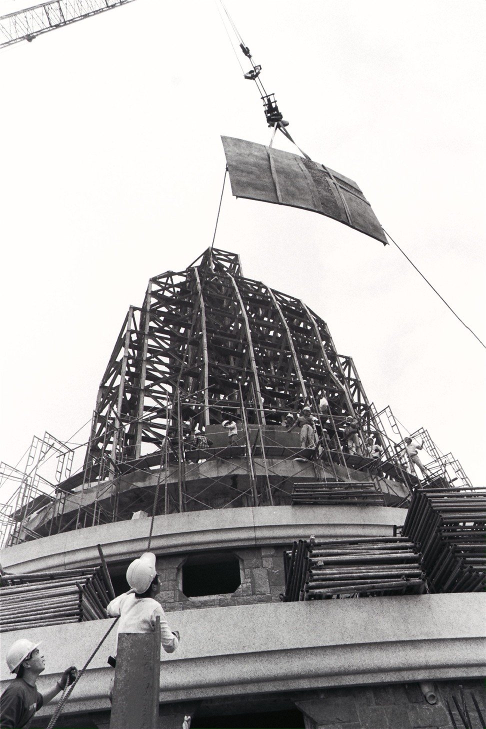 One of the bronze plates from which the Bib Buddha is built is hoisted towards the frame of the statue. Photo: SCMP