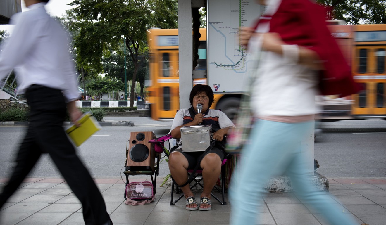 There are only two or three jobs blind people can do in Bangkok, says Yupin Boonchuen, pictured performing in front of a Skytrain station. Photo: AFP