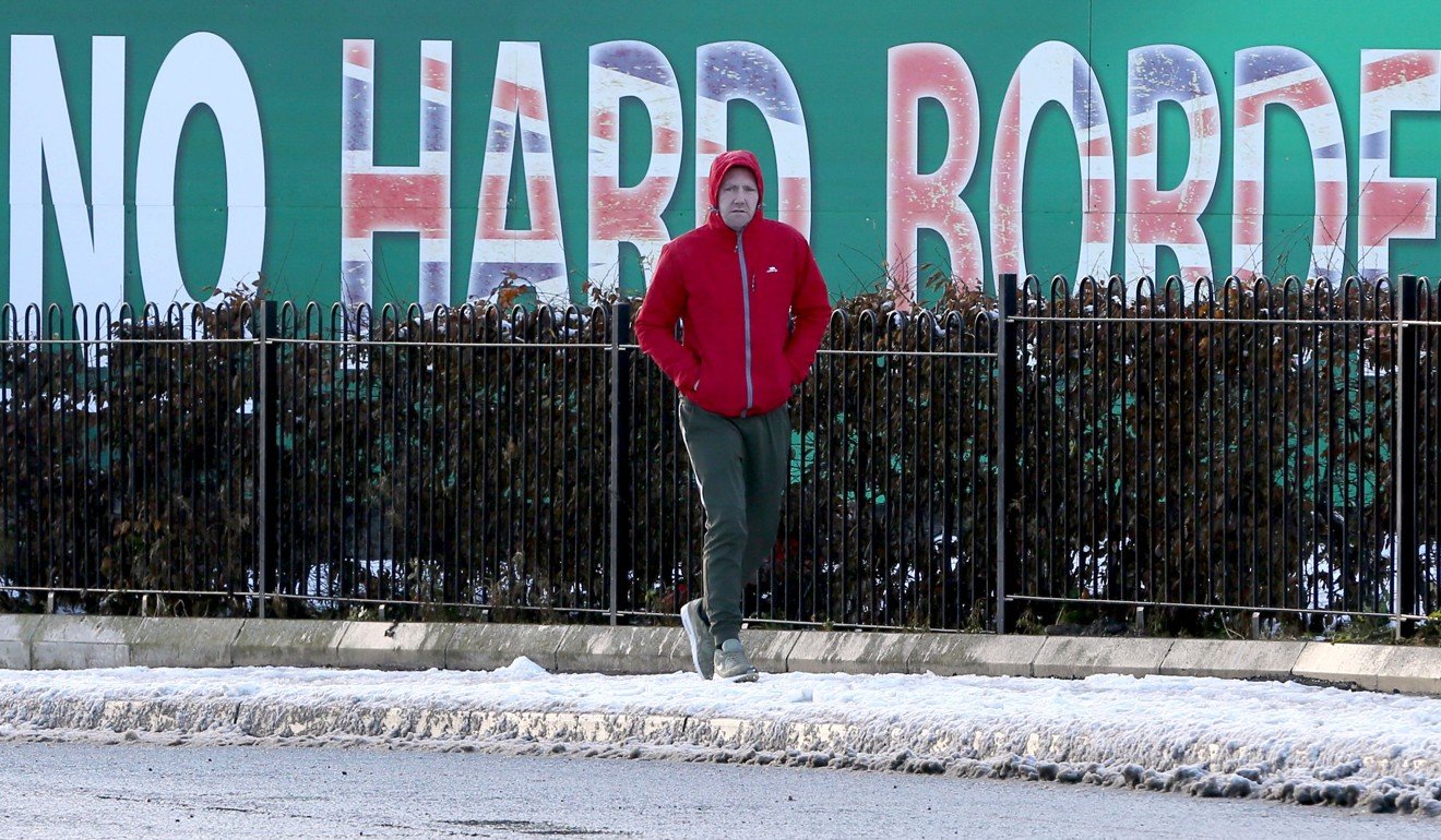 A man walks past a ‘No Hard Borders’ sign in west Belfast, Northern Ireland, in December. Photo: AFP